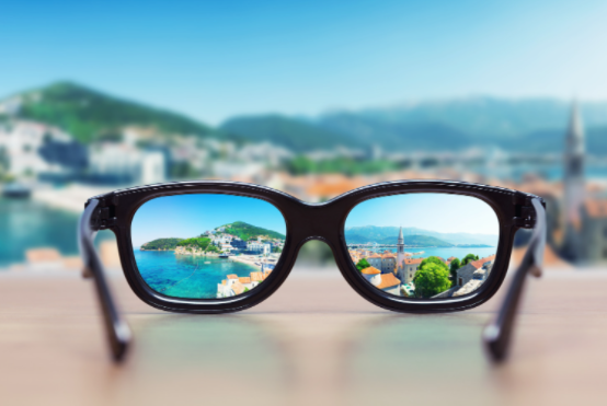 clear view from black glasses lenses perspective, blue sea, green hills